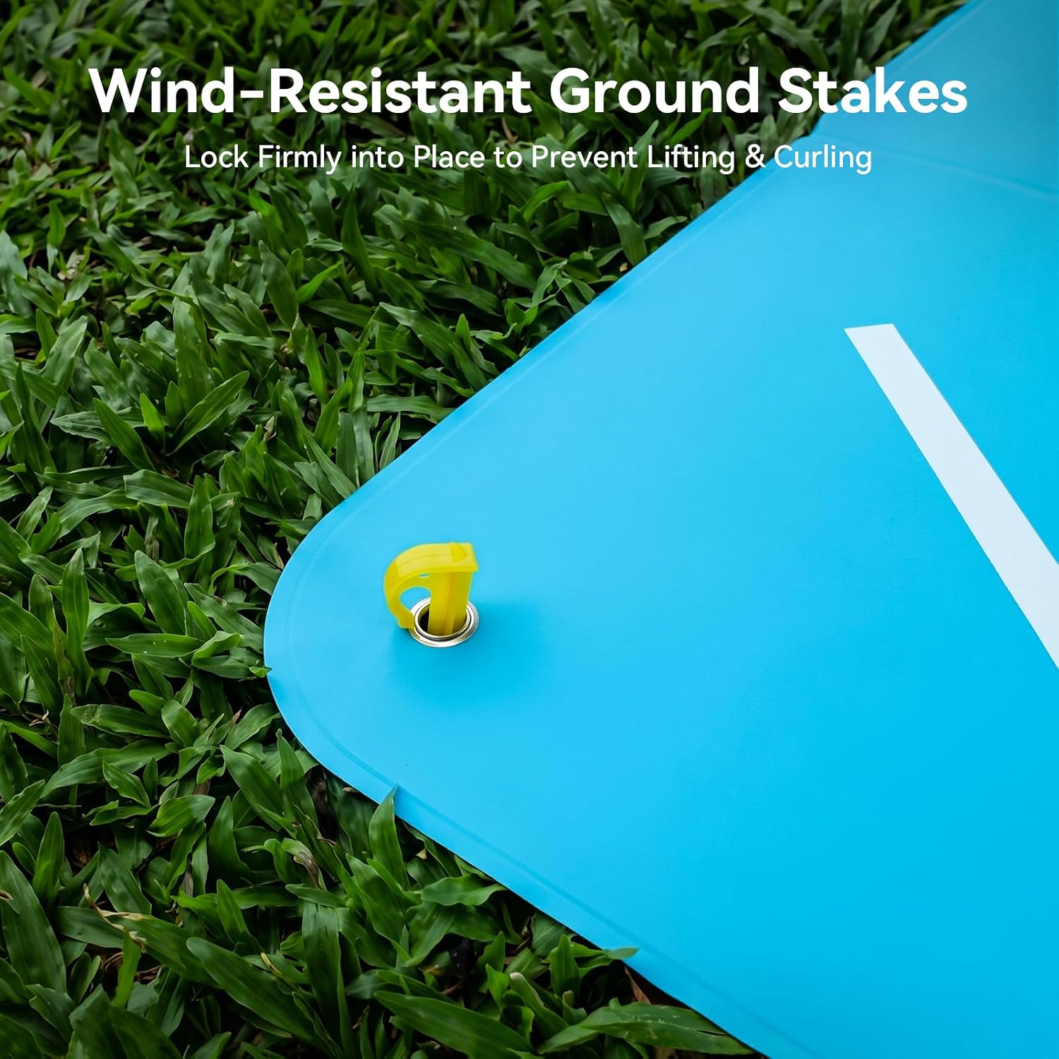 Wind-resistant ground stakes locking a foldable drone landing pad into grass